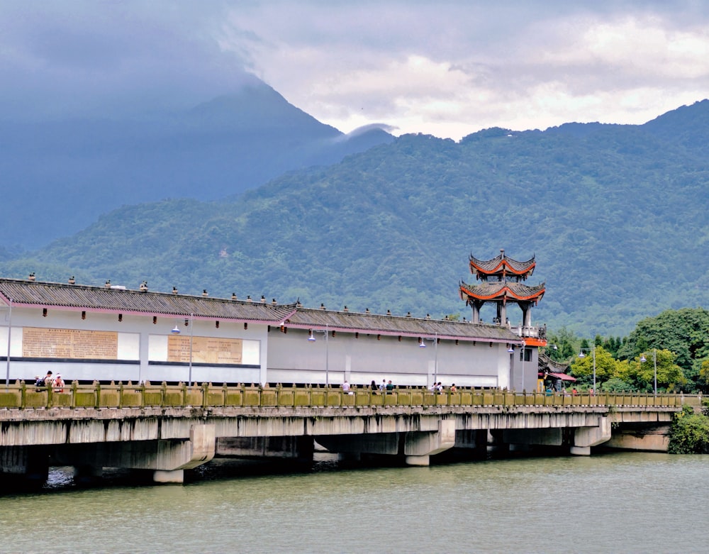 a bridge over a body of water with mountains in the background