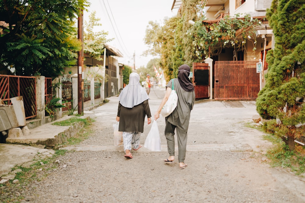 two women walking down a street holding hands