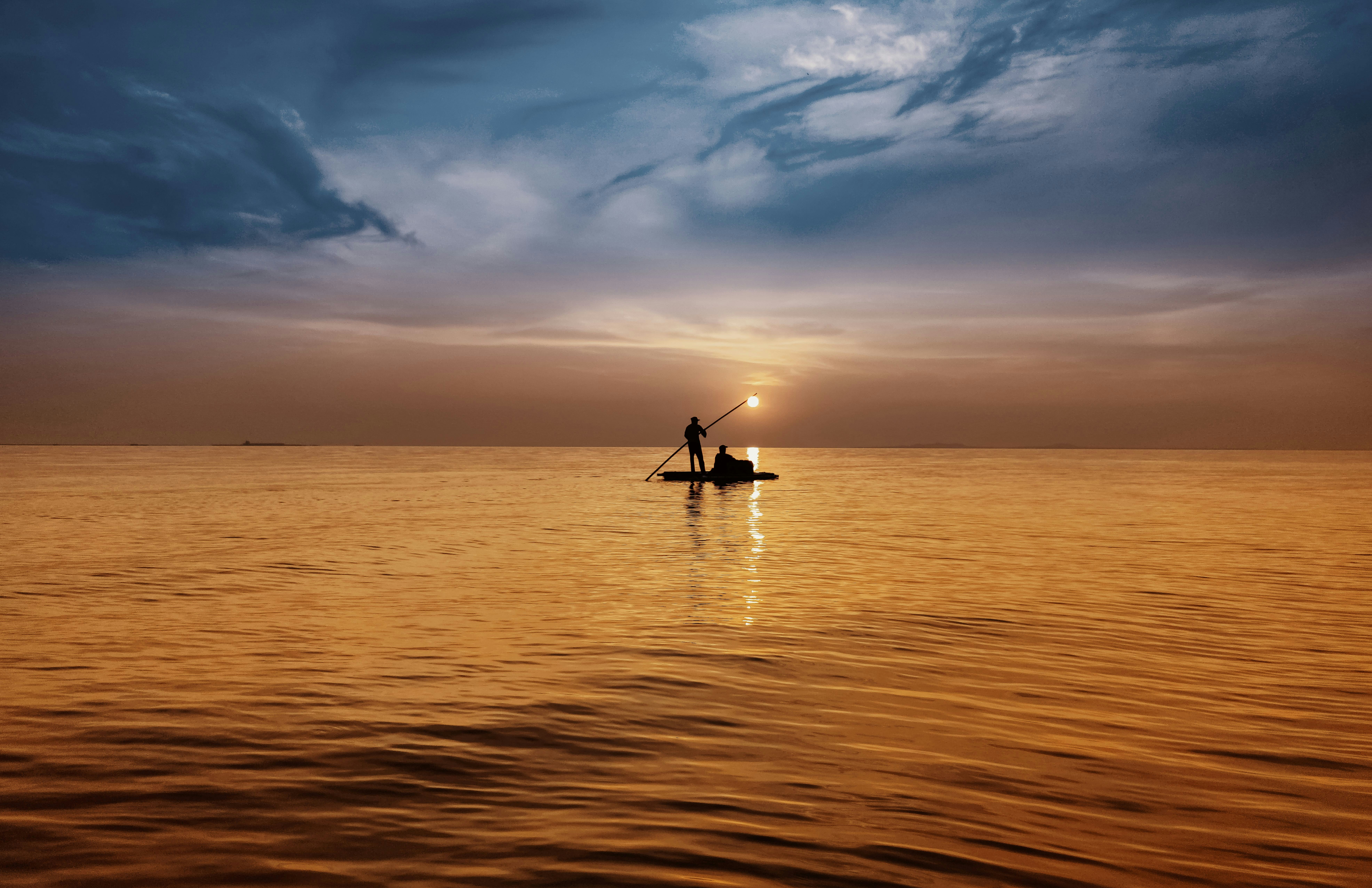A person on a boat in the middle of a body of water photo – Free Sea ...