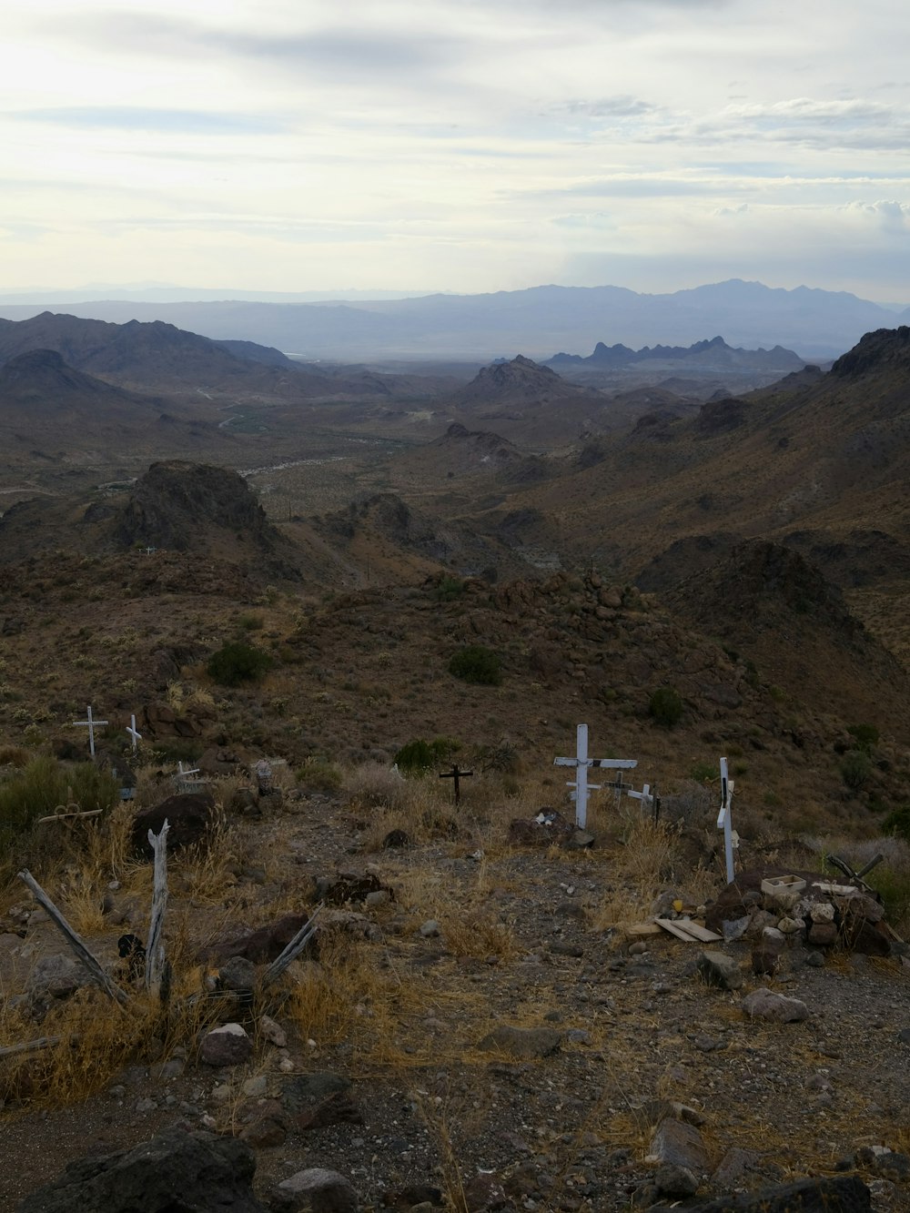a view of a mountain range with crosses in the foreground