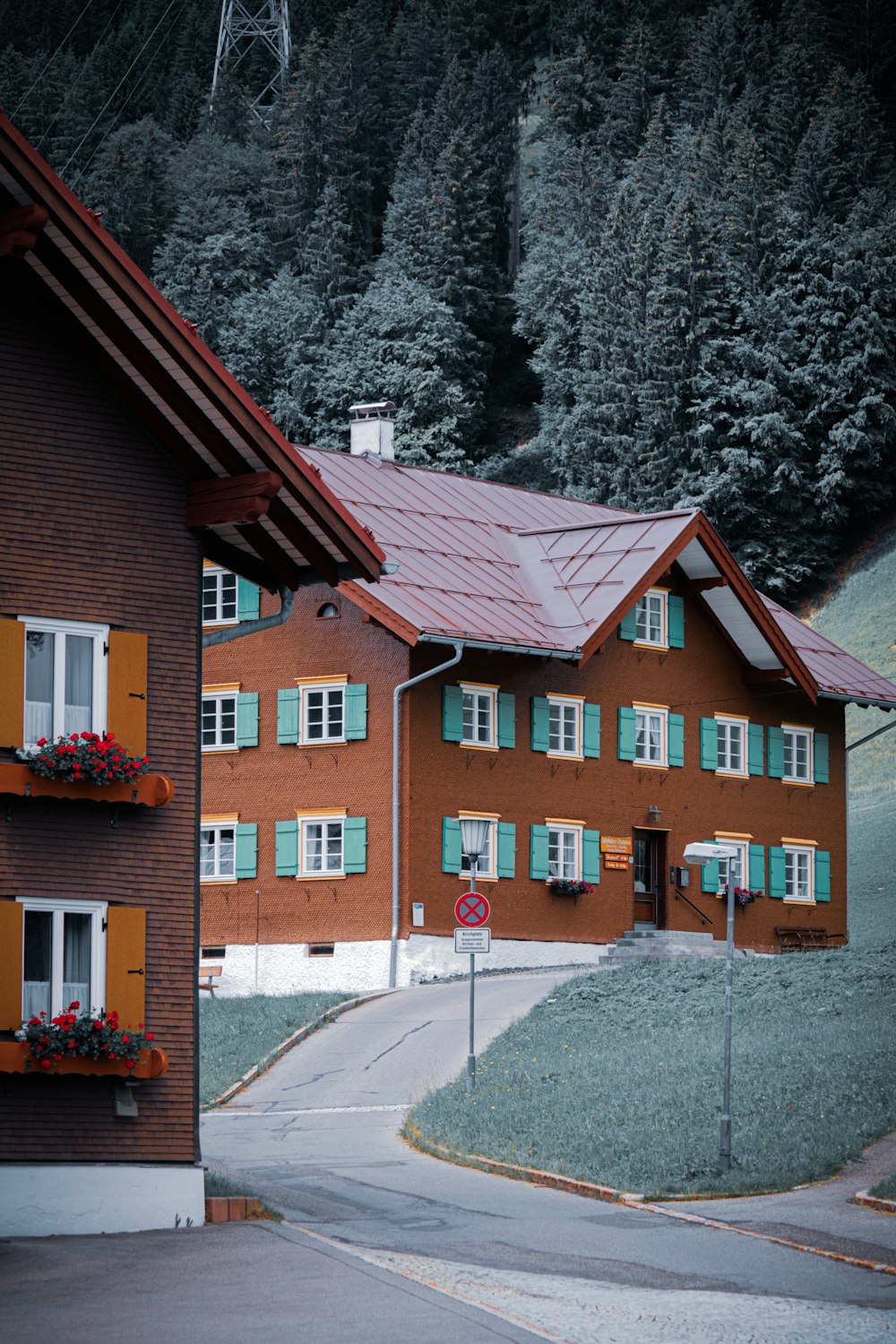 a red building with green shutters and a red roof