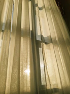 Golden light streaming through translucent curtains, casting gentle shadows