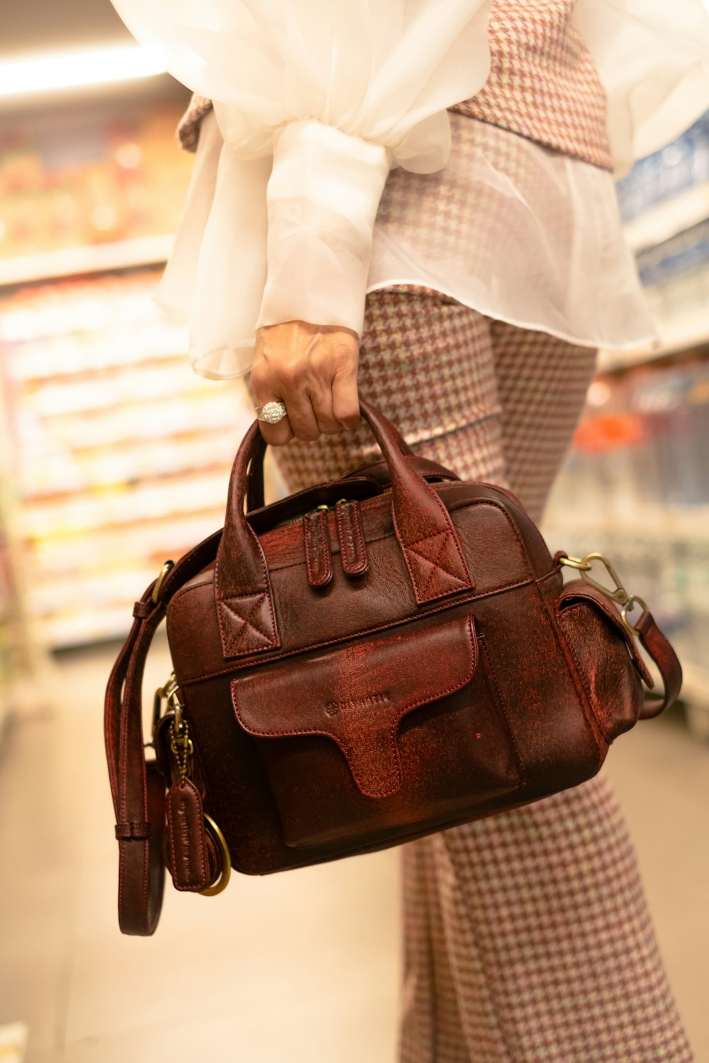 a woman carrying a brown purse in a store