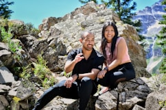 a man and a woman are sitting on rocks