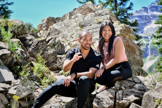 a man and a woman are sitting on rocks
