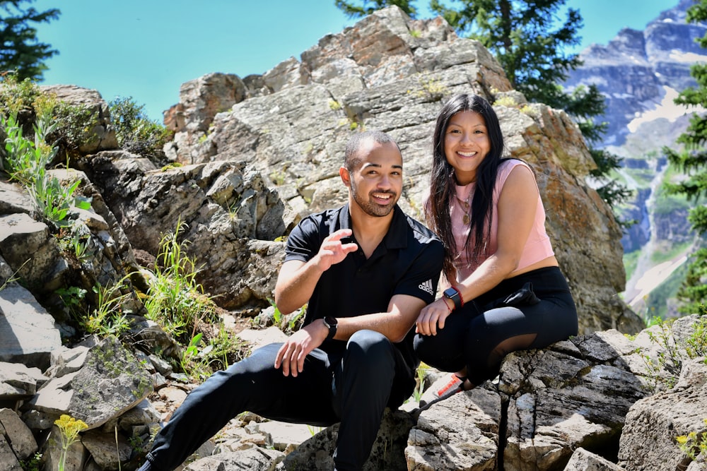 a man and a woman are sitting on rocks