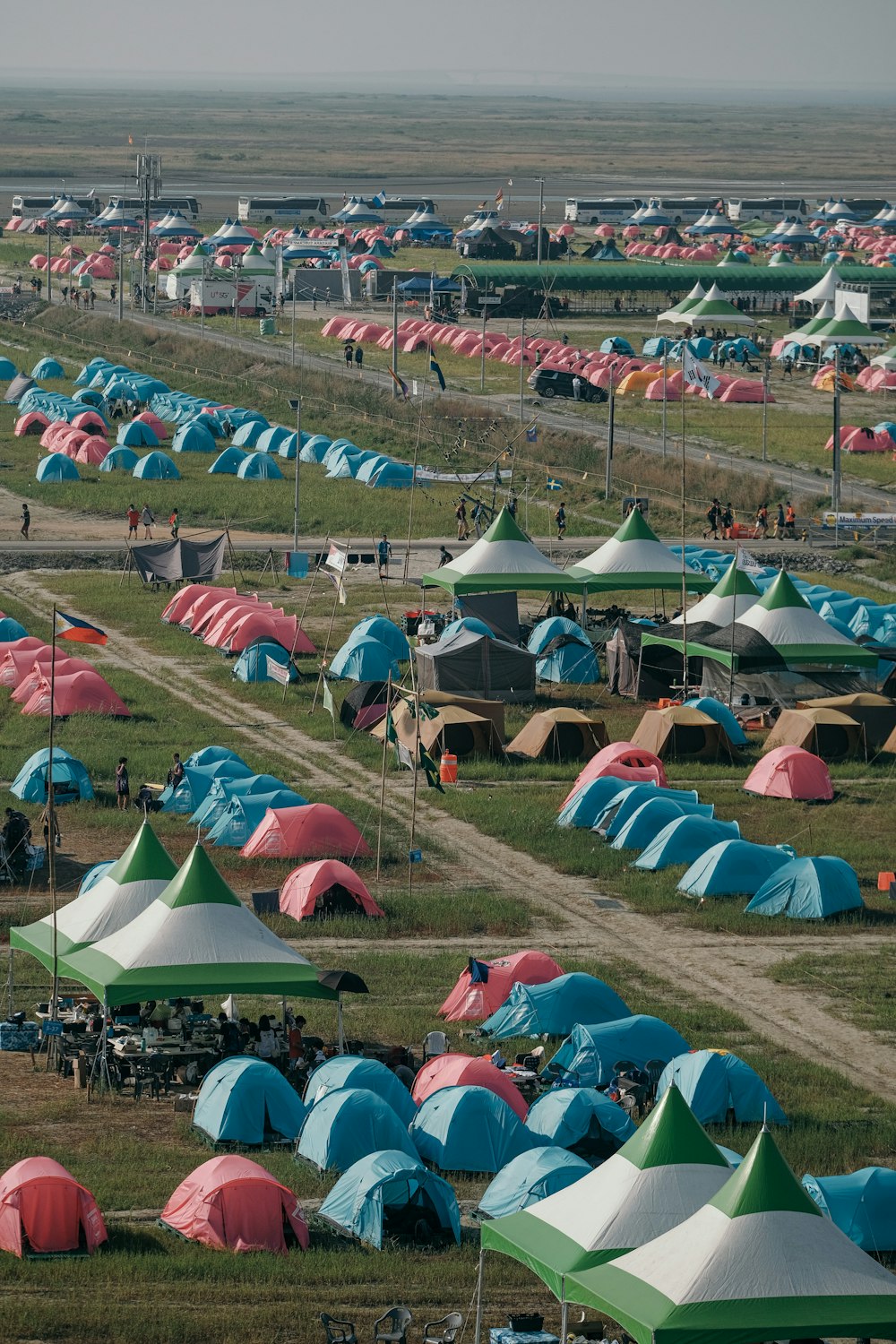 un campo pieno di tende con persone in piedi intorno a loro