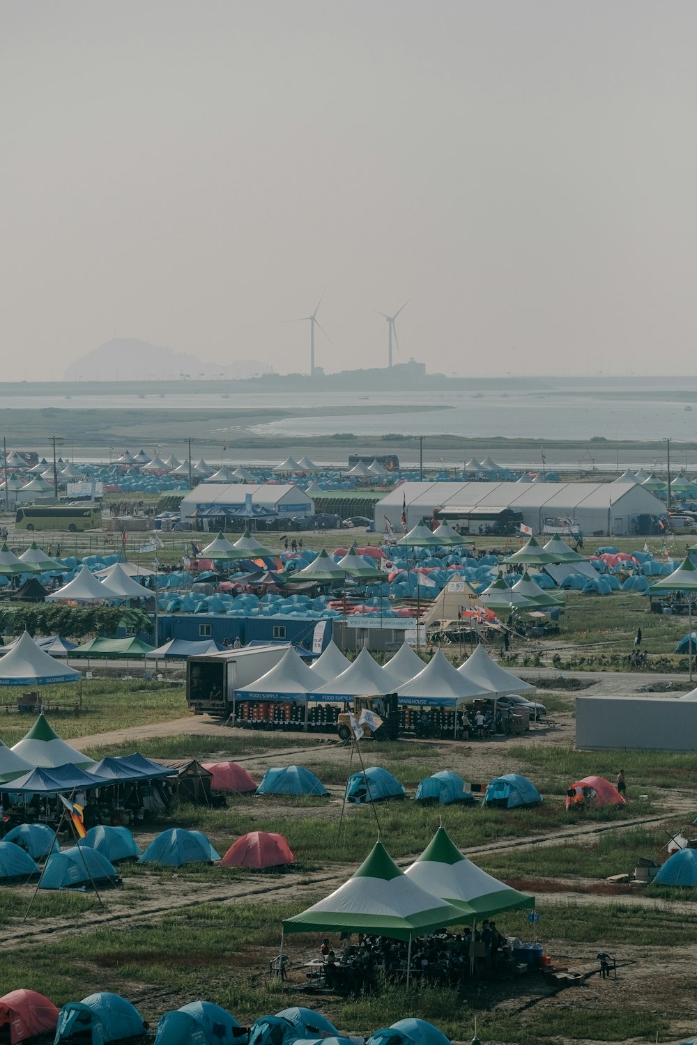 a field full of tents and wind mills