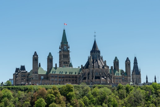 A detailed close-up of the Canadian Parliament building under a clear blue sky.