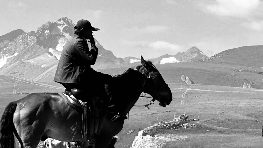 a black and white photo of a man on a horse