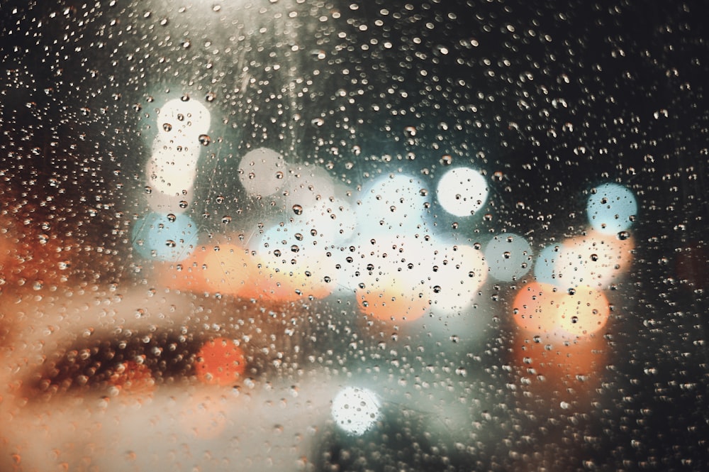 rain drops on a window with a blurry city street in the background