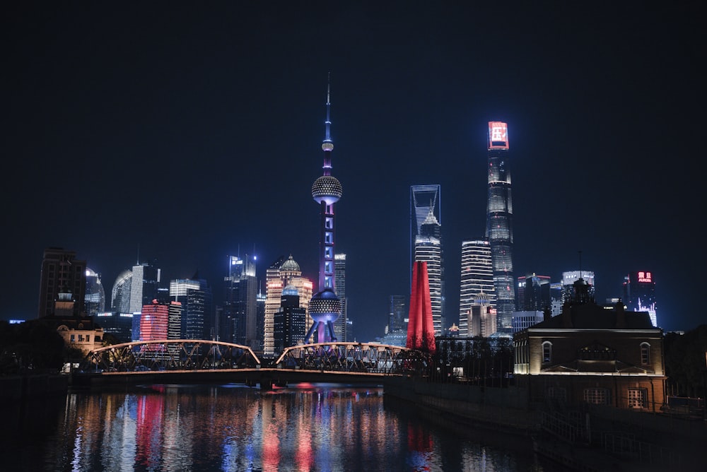 a city skyline at night with lights reflecting in the water