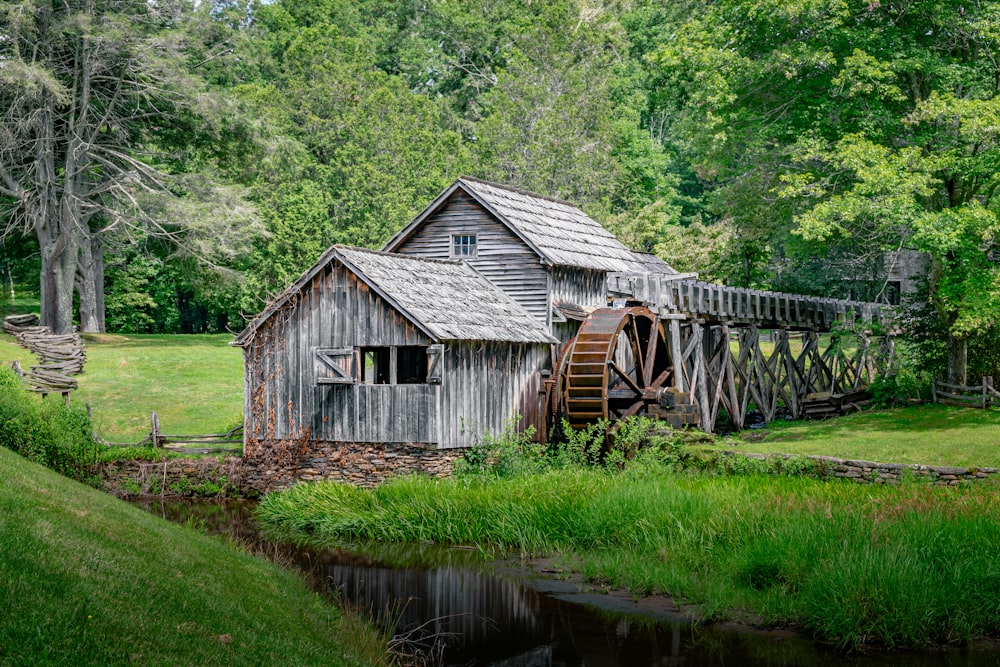 an old wooden water mill in the middle of a field