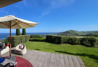 A stylish vacation rental with ocean views and comfortable outdoor seating at sunset.