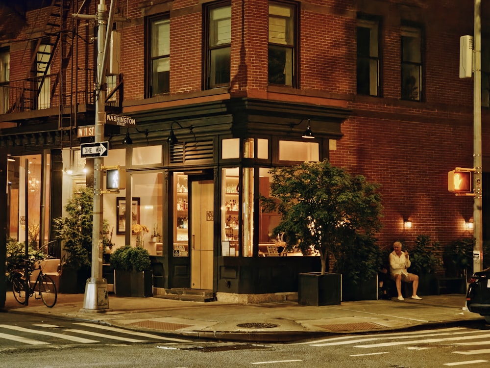 a person sitting on a bench in front of a building