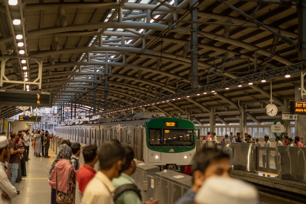 a group of people waiting for a train at a train station