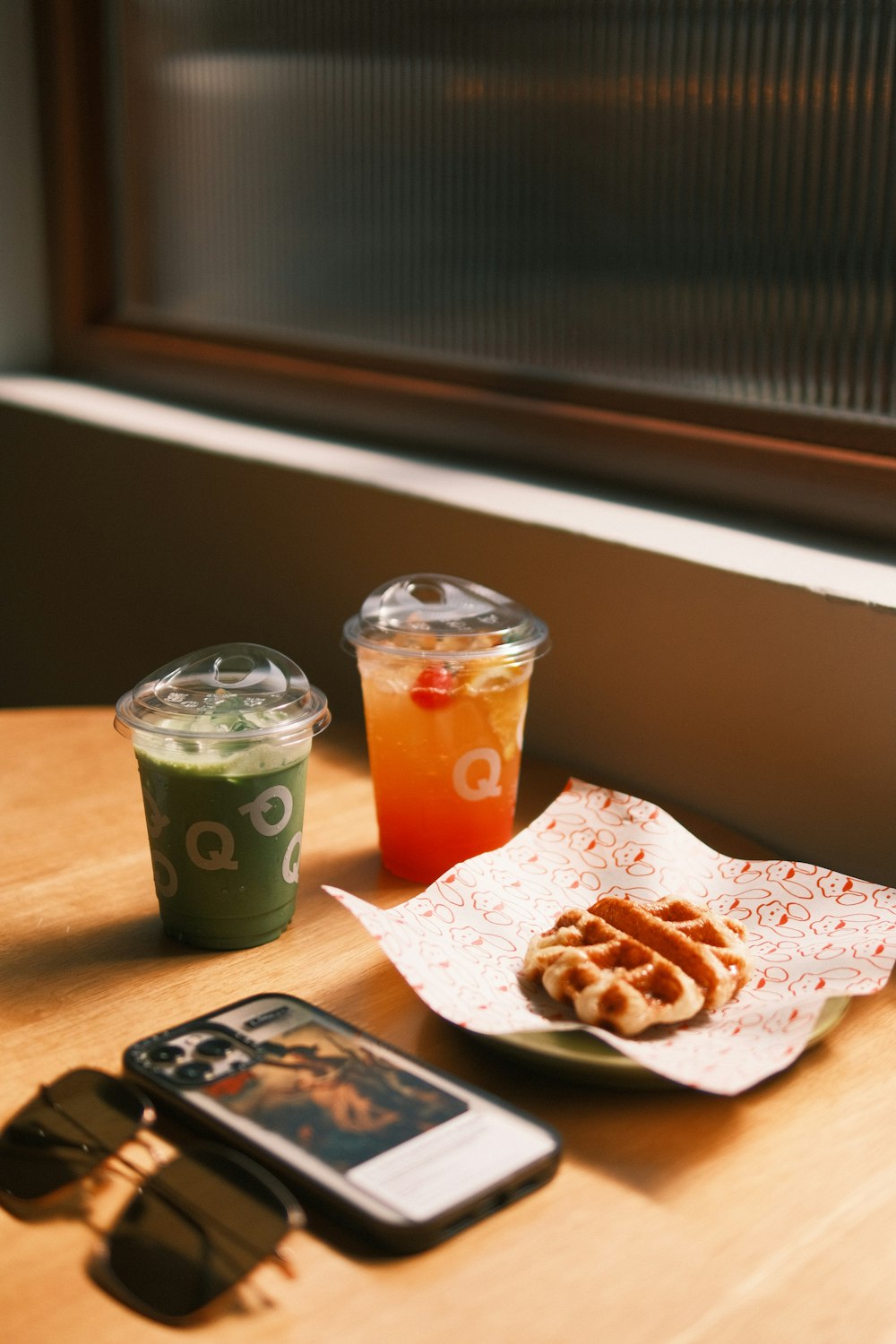 a wooden table topped with a plate of food and drinks