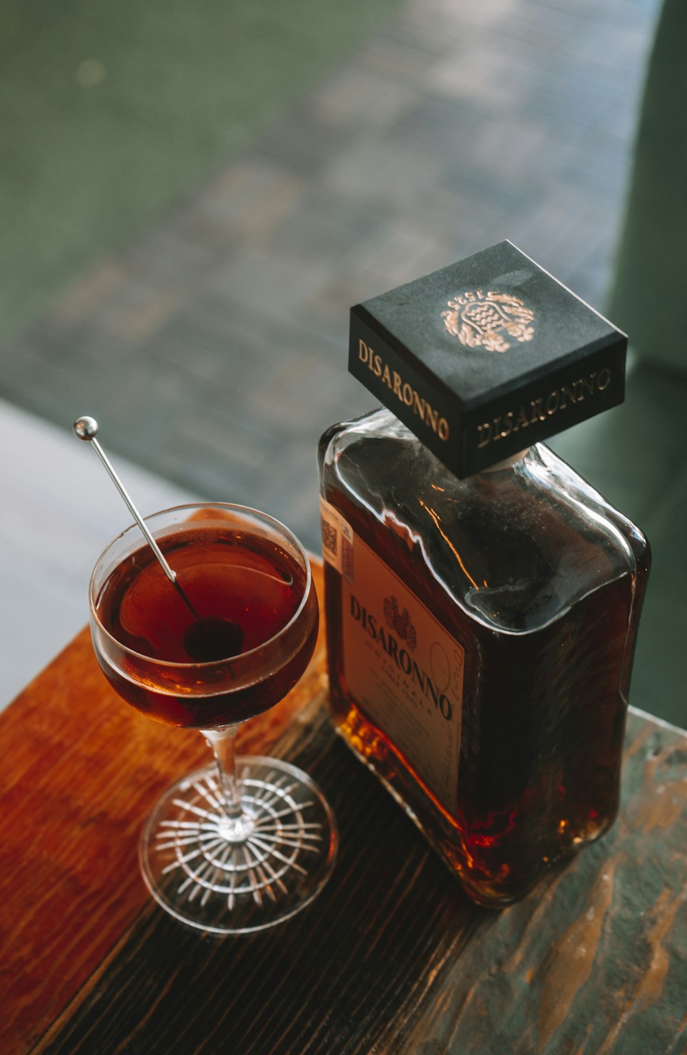 a glass of tea next to a bottle of liquor