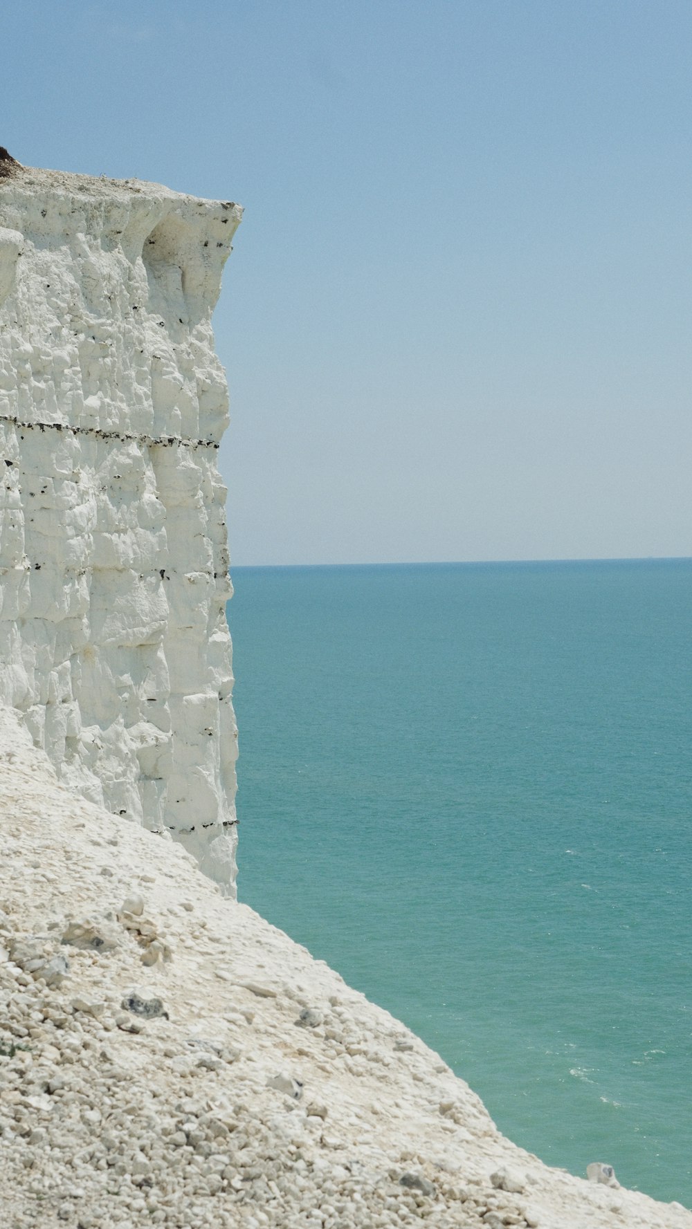 a man sitting on a cliff overlooking the ocean