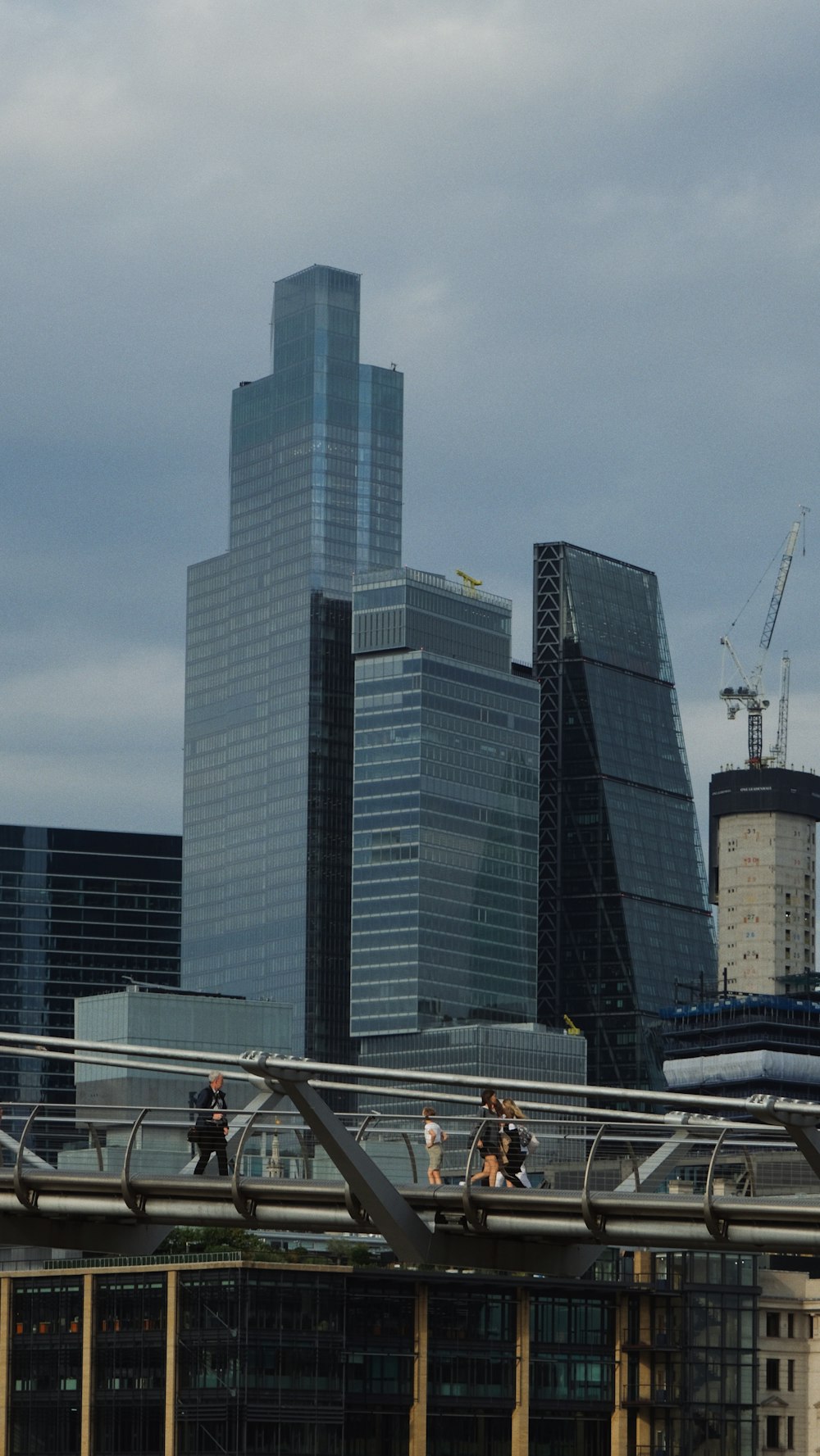 a group of people walking across a bridge