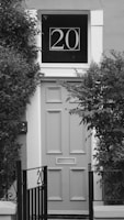 a black and white photo of a door with a sign on it