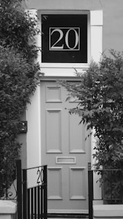a black and white photo of a door with a sign on it
