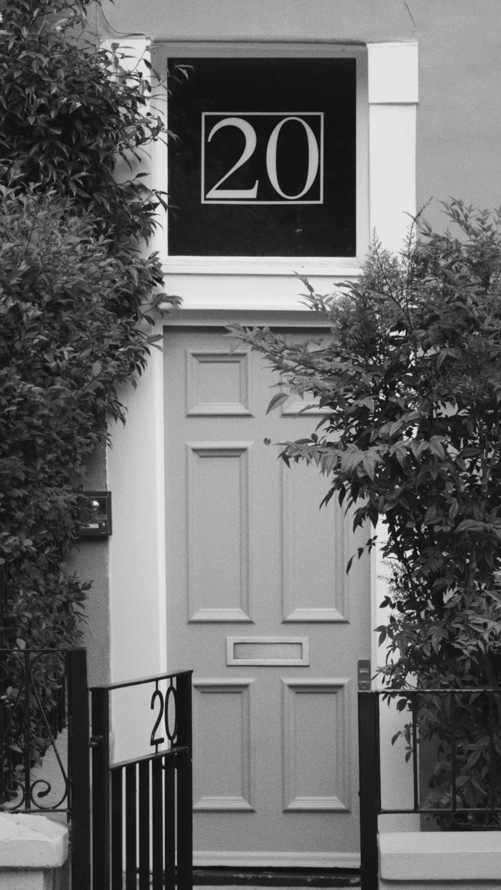 a black and white photo of a door with a sign on it