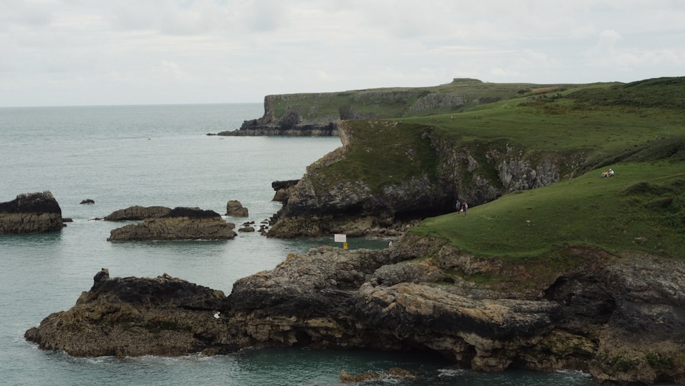 a body of water surrounded by rocks and grass