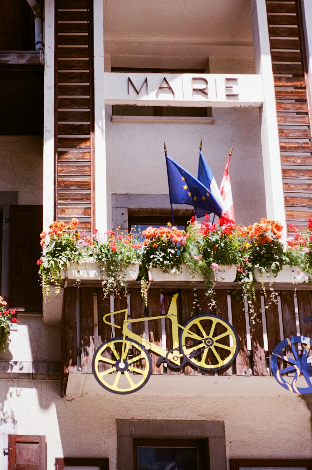 a building with flowers and a bike on the balcony