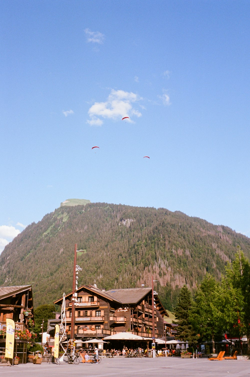 a group of people flying kites in front of a mountain