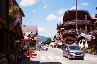 A lively village street adorned with vibrant flowers and rustic alpine buildings.