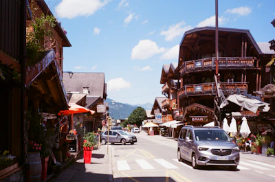 A lively village street adorned with vibrant flowers and rustic alpine buildings.