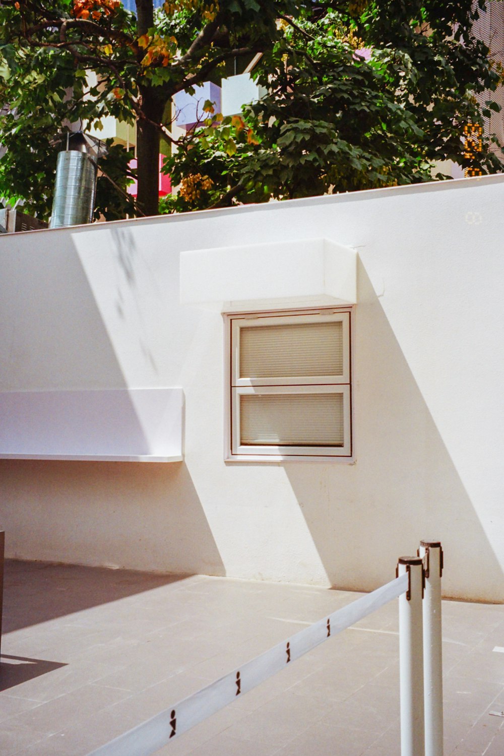 a white building with a window and a white fence