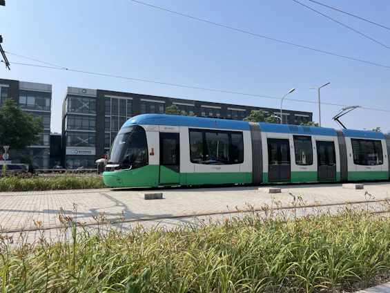 A sleek, modern tram gliding along polished steel tracks beneath a crisp blue sky, symbolizing precision and innovation.