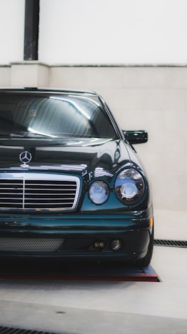 White Mercedes-Benz shining under soft natural light in a showroom.