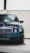 A sleek black Mercedes-Benz car positioned indoors under bright lighting, showcasing its glossy finish and classic front design with a prominent grille and pair of round headlights.