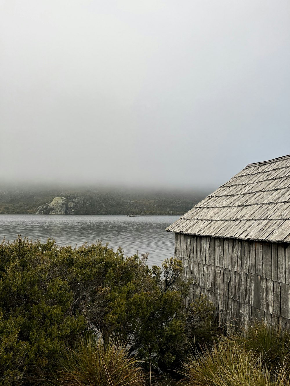 a wooden building sitting next to a body of water