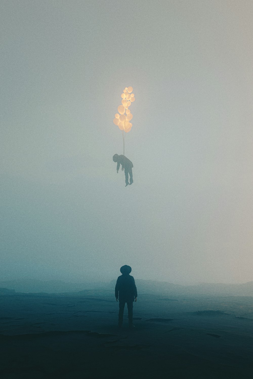 a person standing in a field with a tree in the fog