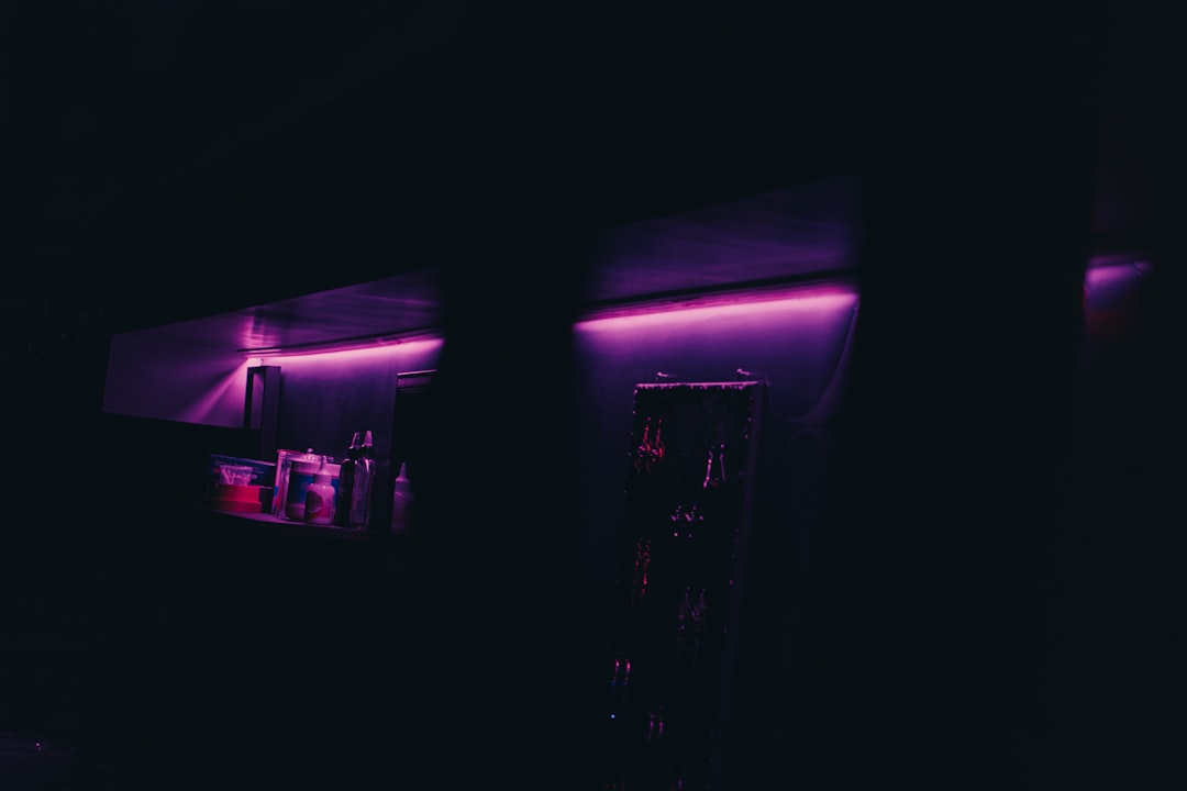 a dark room with a purple light on the wall,