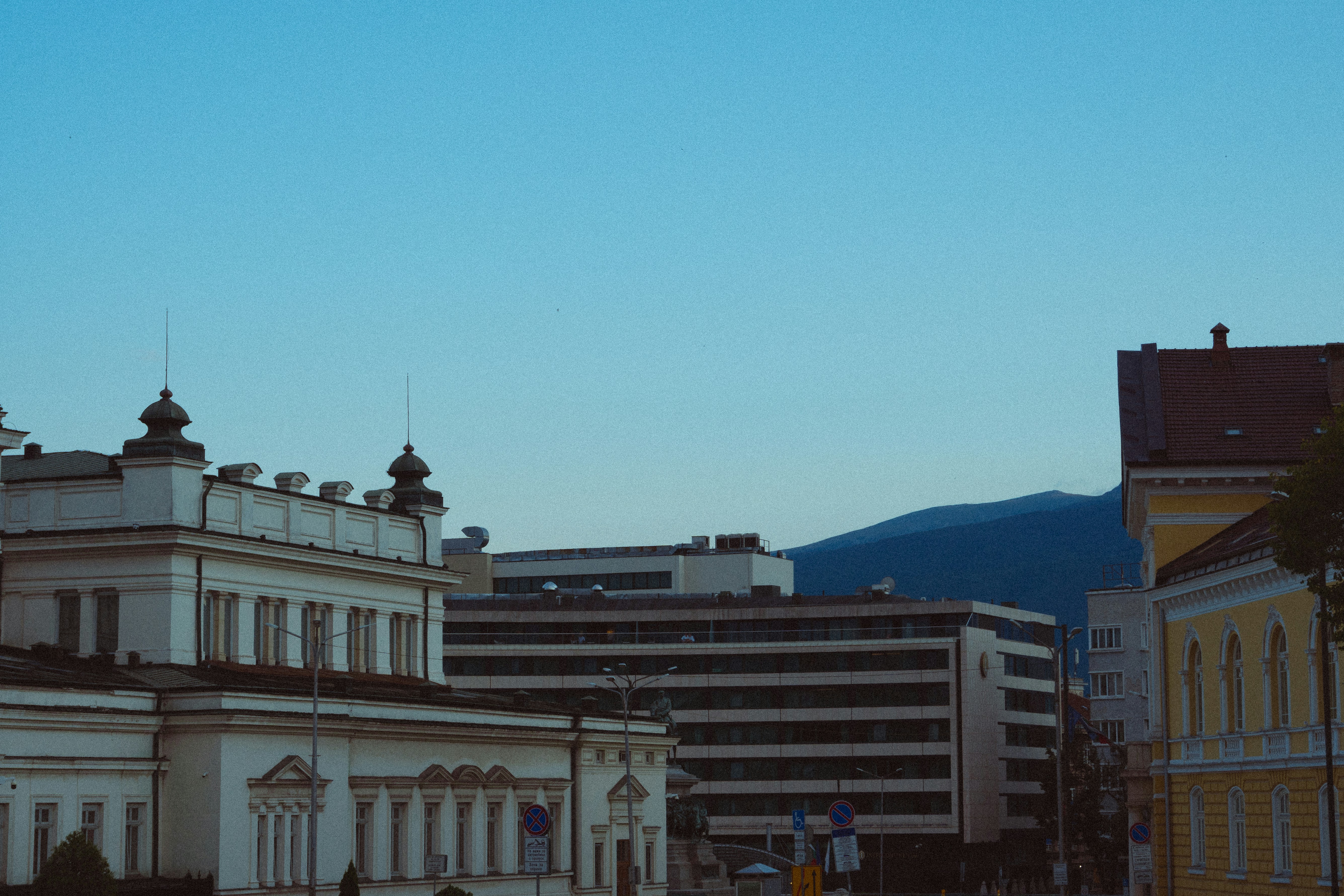 A city street with buildings and a clock tower photo – Free City lights ...