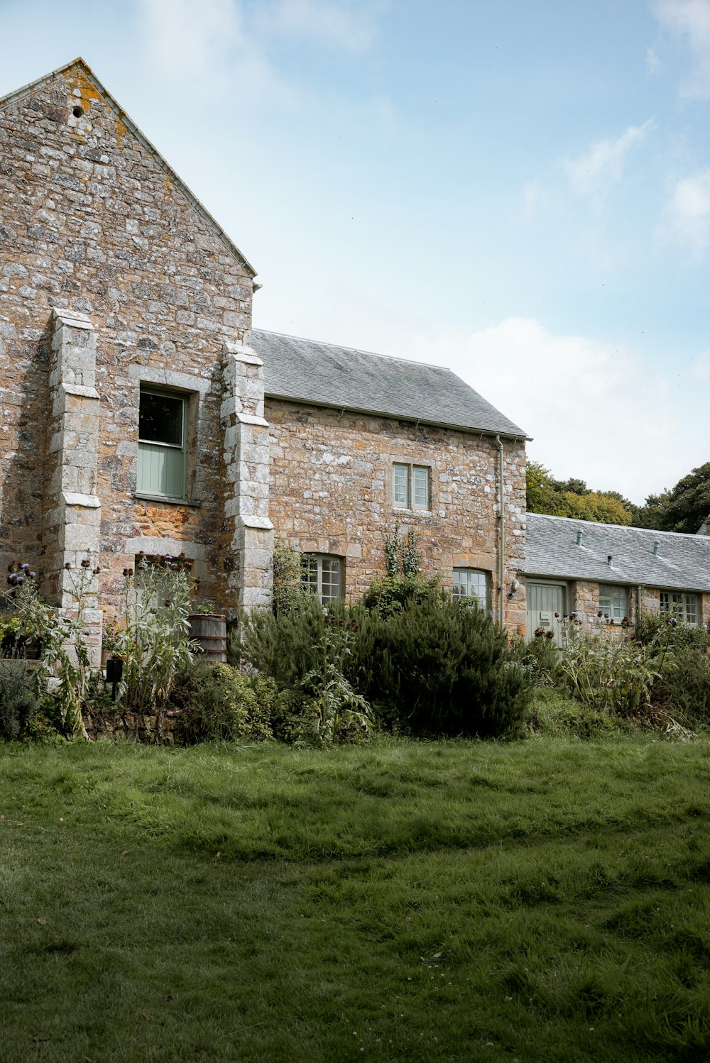 an old brick building with a green lawn in front of it