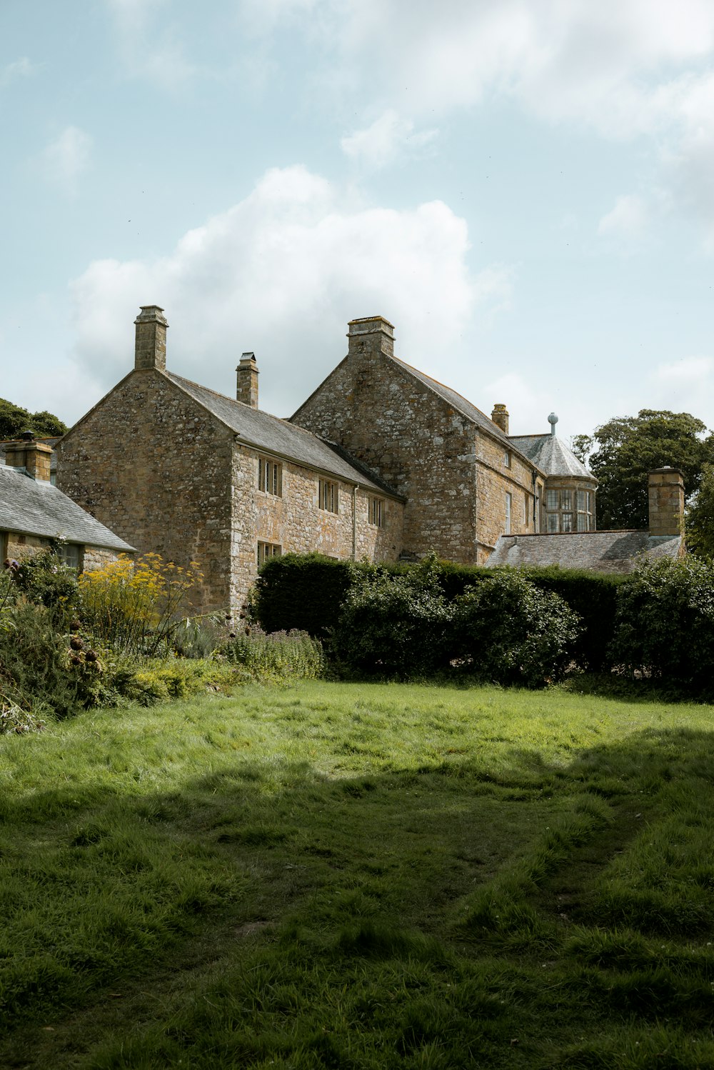 a grassy field in front of a stone building