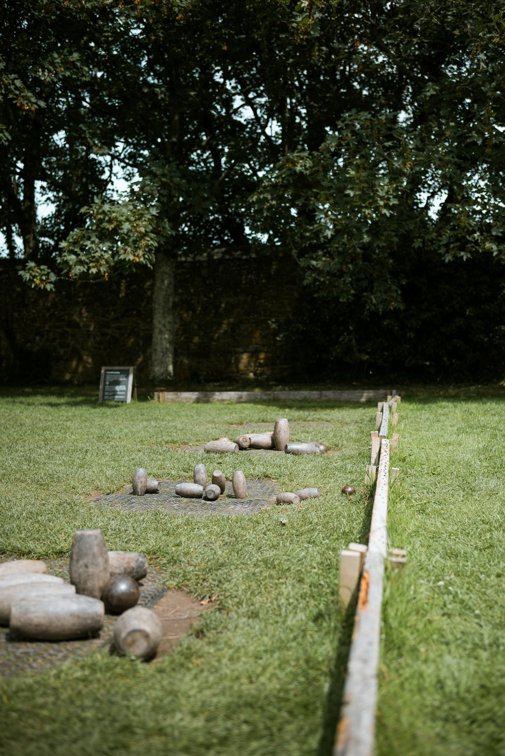 a grassy area with rocks and a wooden fence