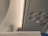 Part of an airplane's interior cabin ceiling, featuring ventilation nozzles, overhead lights, and a sign that reads 'Electronic Devices Off.' The ceiling is predominantly gray and features various panels and fixtures typical of commercial aircraft.