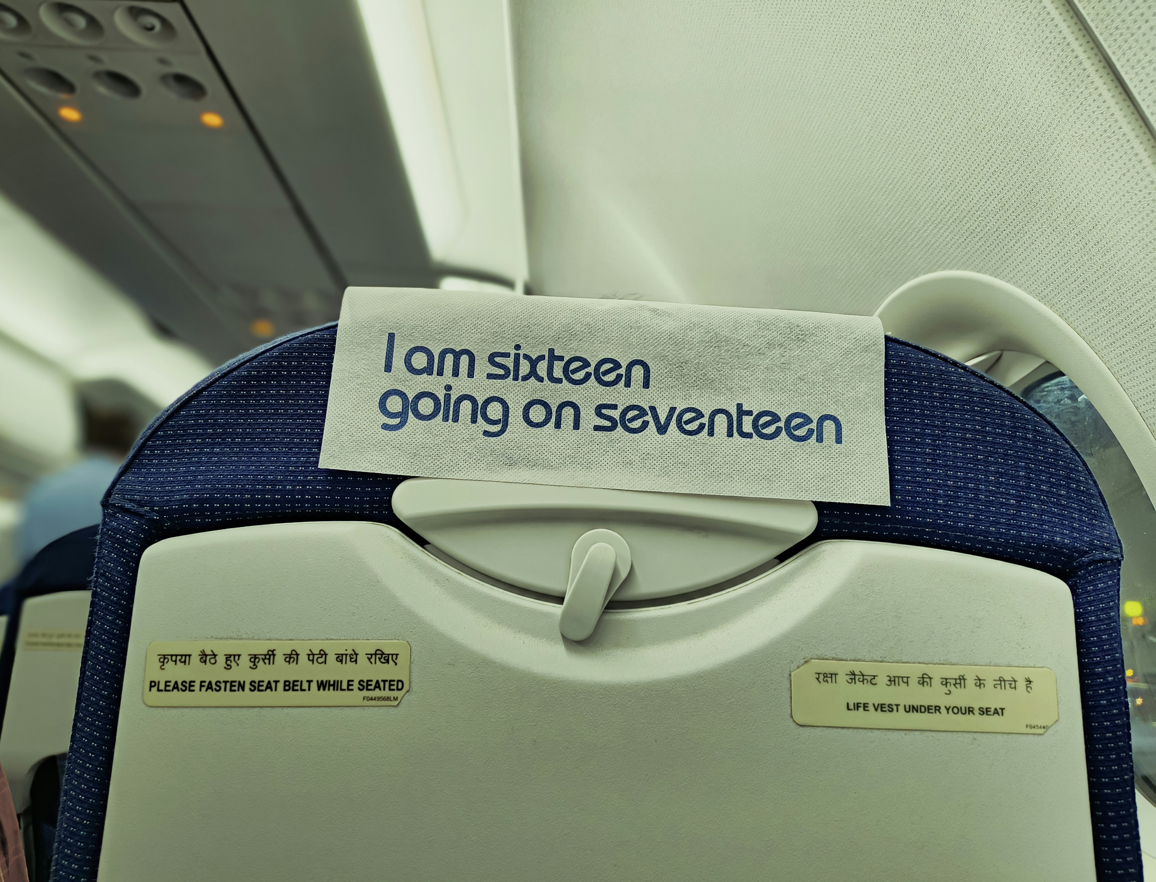 a sign on the back of a seat on an airplane