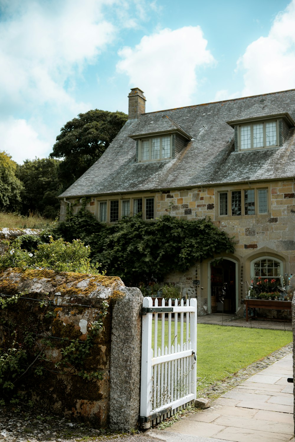 a stone house with a white picket fence