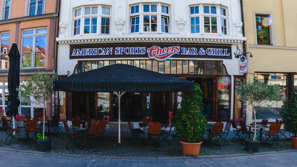 an outdoor restaurant with tables and chairs in front of a building