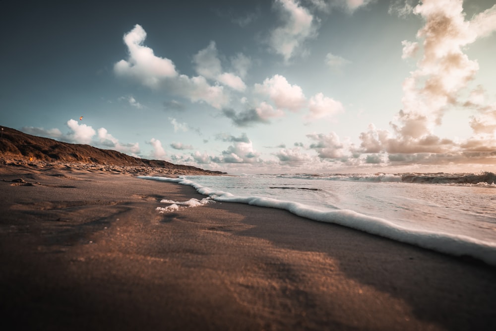 a sandy beach with waves coming in to shore