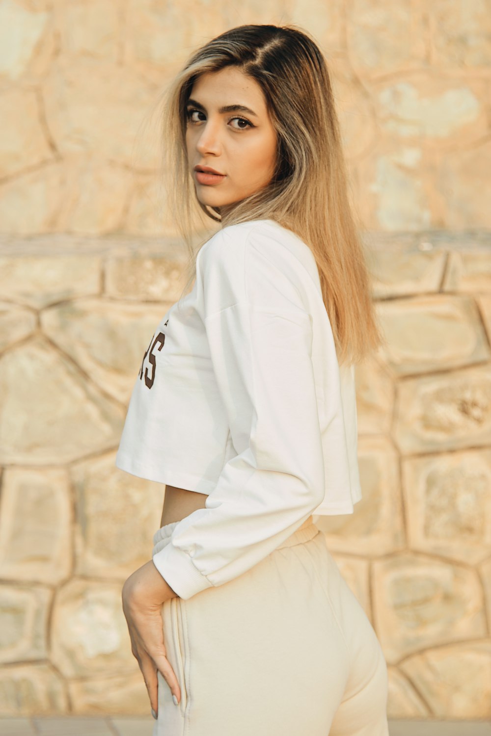 a woman in a white shirt and tan pants