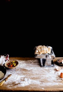 A rustic wooden table with bags of flour and grains scattered around.